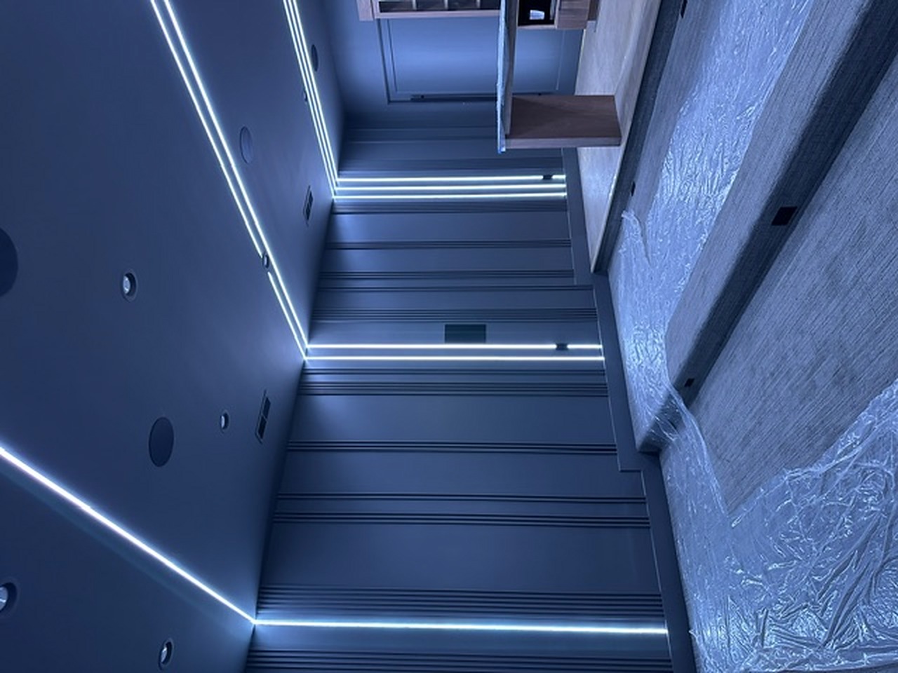Vertical linear LED accents on paneled media room wall