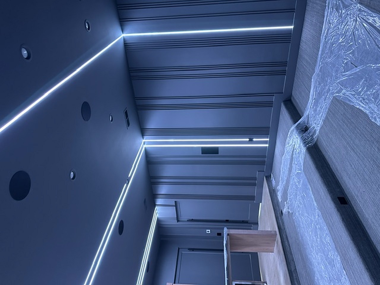Media room with continuous linear lighting and recessed speakers
